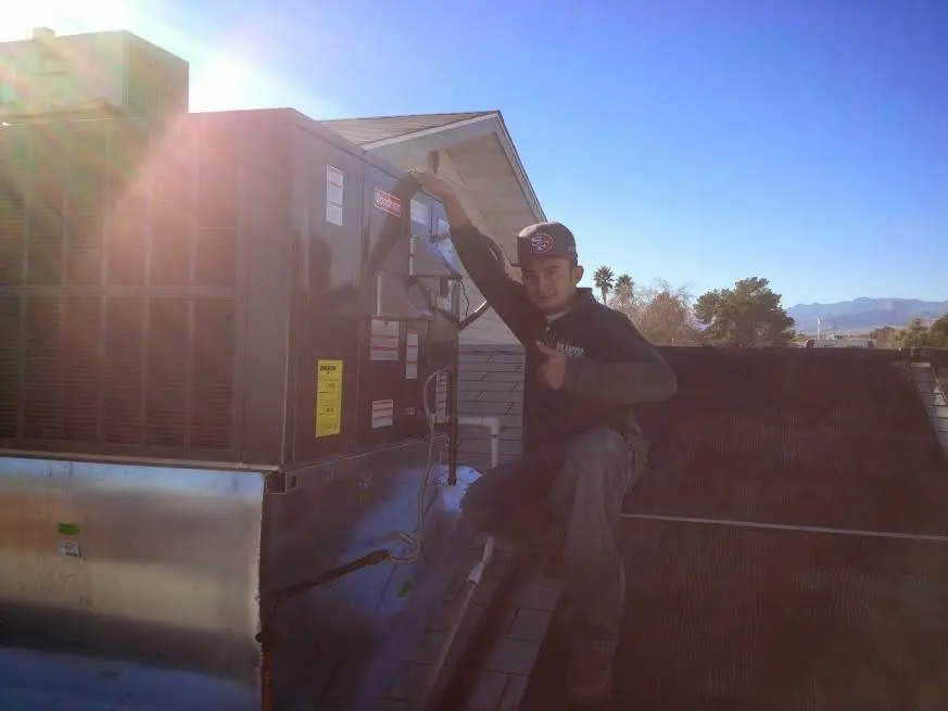 HVAC technician performing AC Tune-Up on a rooftop unit in Demarest